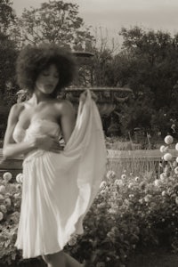 a black and white photo of a woman in a white dress